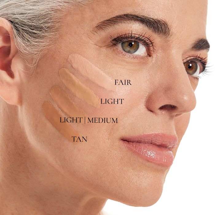 A close-up shows a woman with light skin, brown eyes, and light hair smiling softly. On her cheek are four Nikol Beauty BB CRÈME swatches labeled Fair, Light, Light/Medium, and Tan. The BB CRÈME is enriched with Kakadu Plum for a radiant glow.