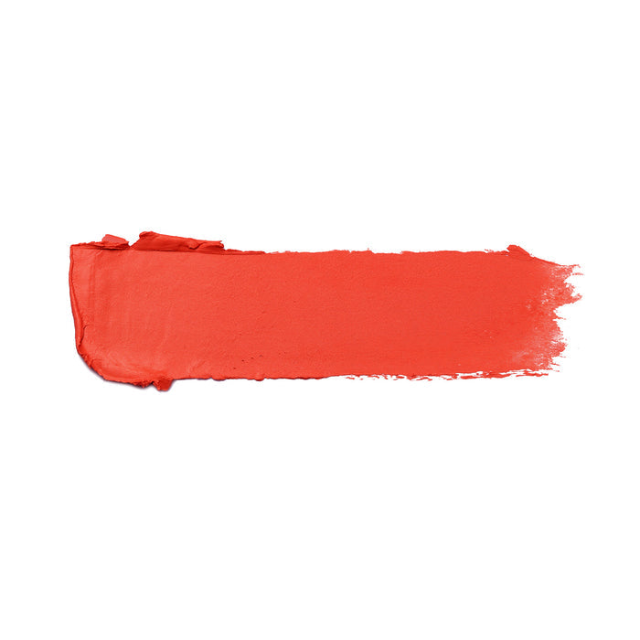 A bold, horizontal smear of Beach House Shiny Velvet Cream Lipstick #122 by Nikol Beauty, in a bright coral-orange shade with a creamy texture and uneven edges on white background, enriched with nourishing shea butter for added moisture.