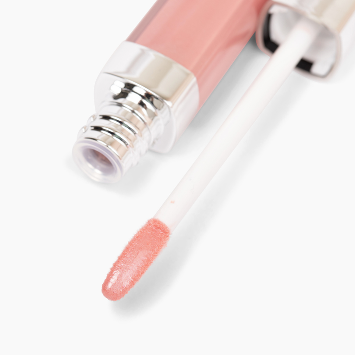Close-up of Champs Lip Gloss #461 by Nikol Beauty, featuring a non-sticky formula in a soft pink shade for high-impact shine. The tube has a metallic cap, and the white applicator wand is coated in pink gloss.