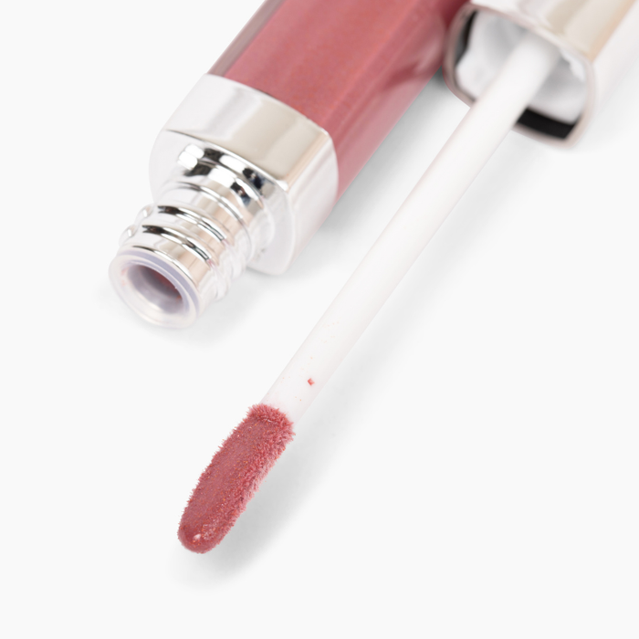A close-up of Nikol Beautys Coco 13 Lip Gloss #259 reveals a shimmering pink doe-foot applicator. Its high-impact shine enhances lips, while the metallic accent at the opening lends elegance, embodying clean beauty standards.