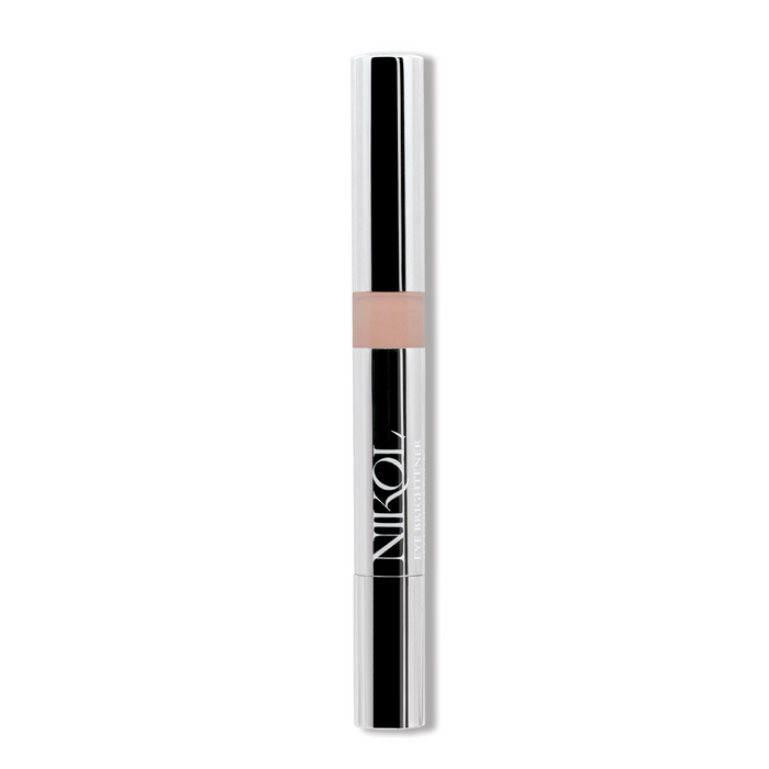 A sleek, silver cylindrical eye brightener from Nikol Beauty features a clear section displaying a light beige shade. Nikol is printed in white letters, and it is infused with chamomile flower water for a soothing application.