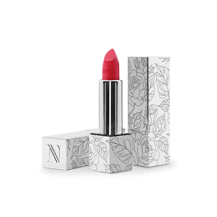 Nikol Beauty’s Fleur Shiny Velvet Cream Lipstick #34, a vibrant pink shade in a silver and white floral tube, features a vegan hydrating formula perfect for mature lips. The cap stands upright next to it on a plain white background.