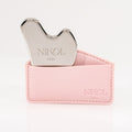 A silver Gua Sha Stainless Steel facial massage tool by Nikol Beauty, partially placed in a light pink leather holder embossed with the brand name, ideal for lymphatic drainage, set against a white background.