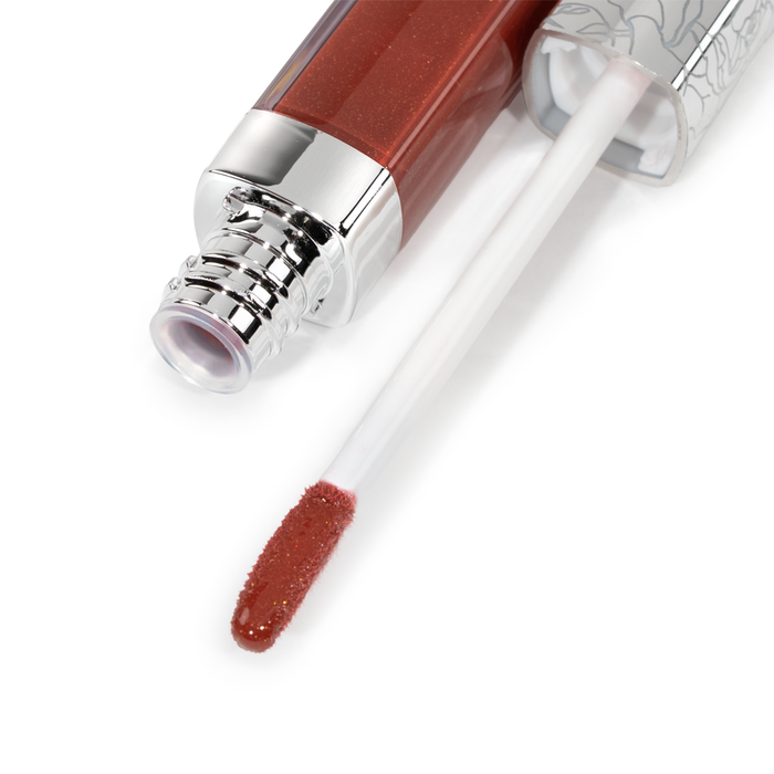 A close-up of Nikol Beauty’s Ignite Lip Gloss #176, featuring a silver-capped tube and wand coated in shimmery, high-shine reddish-brown gloss—ideal for adding sophisticated flair to any look.