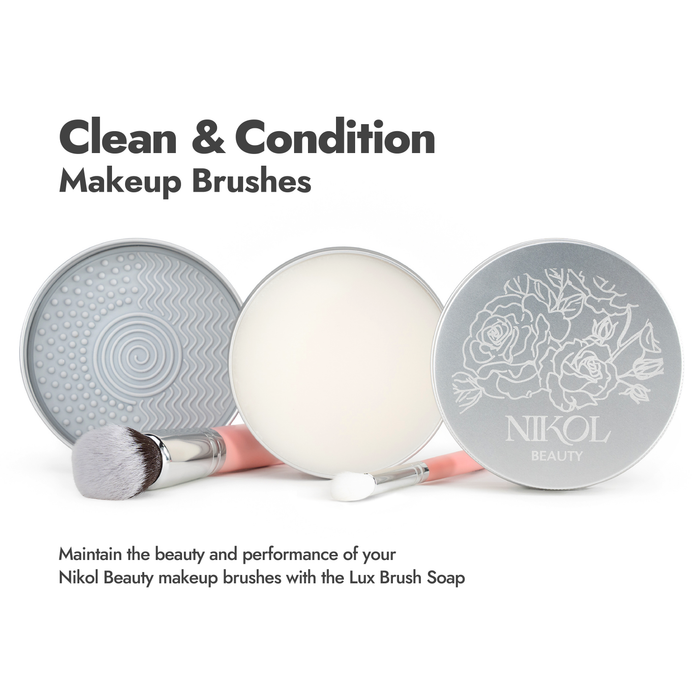 Open containers of Nikol Beauty Lux Brush Soap and a textured pad are displayed with two brushes—one clean, one covered in soap. Use Lux Brush Soap to clean and condition your Nikol Beauty brushes, helping maintain their beauty and performance.