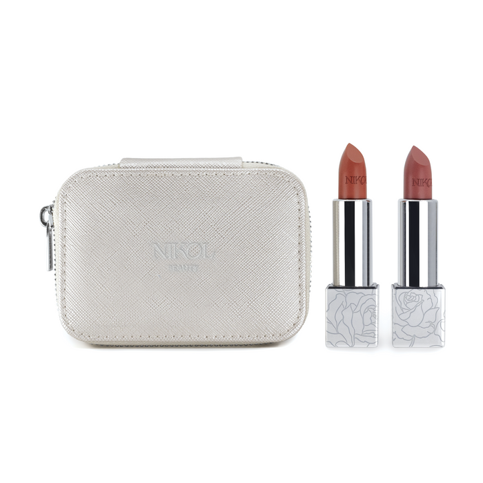 The Nikol Beauty Lipstick Case by Nikol Beauty features a metallic makeup case with a zipper, built-in mirror, and two nude shades of lipstick. The lipstick tubes have floral-patterned bases.
