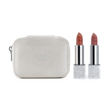 The Nikol Beauty Lipstick Case by Nikol Beauty features a metallic makeup case with a zipper, built-in mirror, and two nude shades of lipstick. The lipstick tubes have floral-patterned bases.