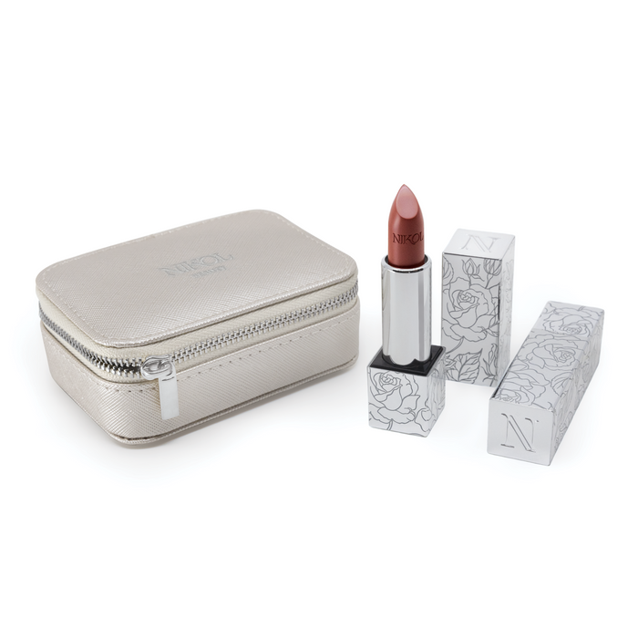 A vegan metallic makeup bag is next to a Nikol Beauty Lipstick Case with a rose-patterned silver design. The partially extended nude shade lipstick inside is ready to enhance any look.