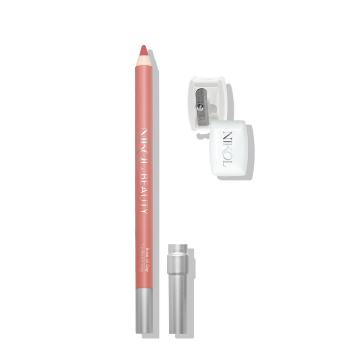 A pink lip pencil bearing Nikol Beauty is paired with a clear sharpener and silver cap, ready for professional use. Its pointed tip ensures precision, making it indispensable in any makeup bag on a plain white background.