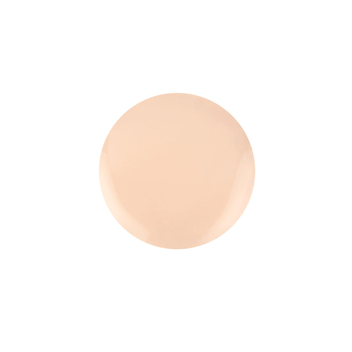 A round swatch of light beige nail polish with a smooth, glossy finish mirrors the creamy hue of Nikol Beautys Serum Foundation. Set against a white background, its subtle sheen underscores a commitment to clean beauty and elegant simplicity.