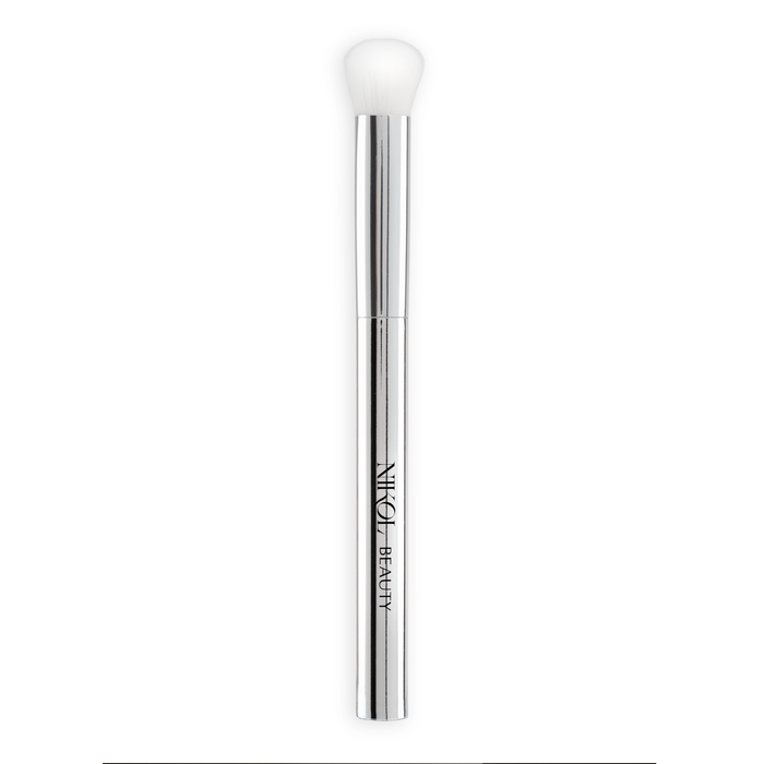The SOFT SET TECHNIQUE™ BRUSH by Nikol Beauty is a silver vegan under-eye setting brush with a white, rounded bristle head and "Nikol Beauty" printed vertically on the metallic handle. Ideal for flawless results on mature skin, against a plain white background.