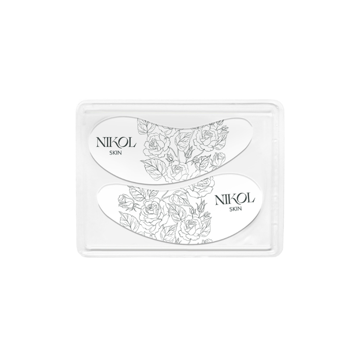 The These Bags Are Designer-Eye Mask by Nikol Beauty features black floral designs and branding, packaged in a clear tray against a white background, providing stylish under-eye hydration.