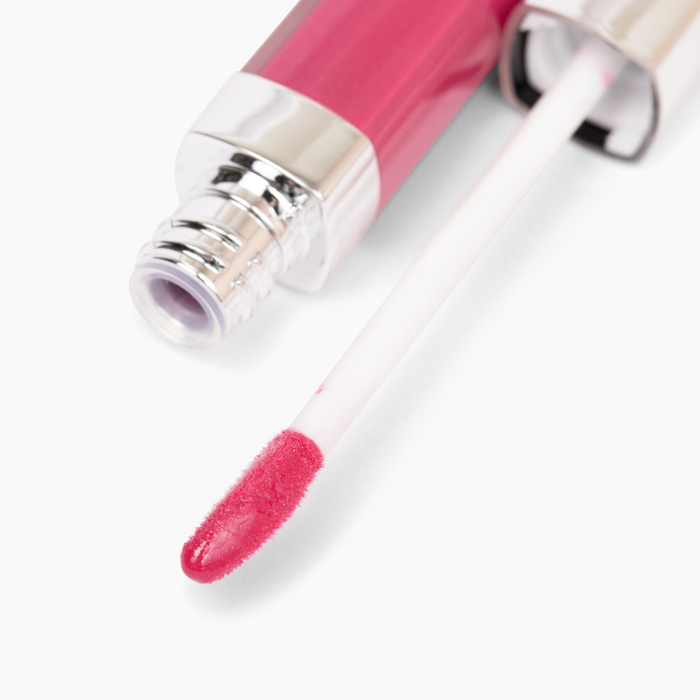 A close-up of Nikol Beautys Upgrade Lip Gloss #94, a cruelty-free pink gloss with a silver cap, features an applicator wand coated in shiny pink color, set against a white background.